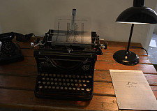 Bild von einem Holztisch mit Schreibmaschine und Lampe