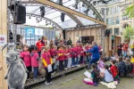 Blick auf die Bühne wo Schülerinnen und Schüler singen.