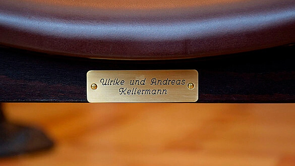 Ein Messingschuld auf der Rückseite von einem der Stühle im Bremer Rathaus.