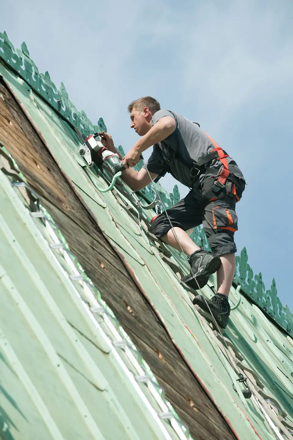 Arbeit am Dachfirst: Aufschneiden der Falze zwischen den alten Kupferscharren &copy;LIS/Michael Schnelle
