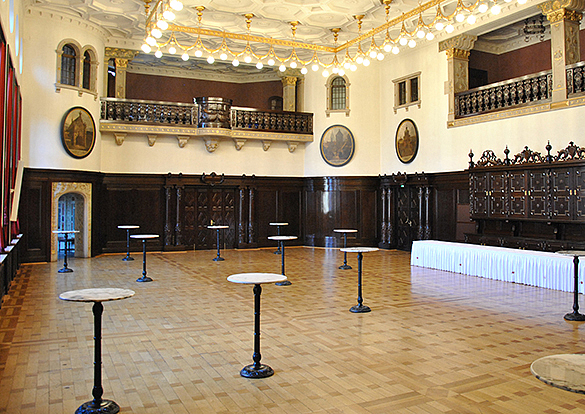 Bild vom Festsaal: Raum ist unten mit Holz vertäfelt. Im oberen Bereich ist eine Gallerie