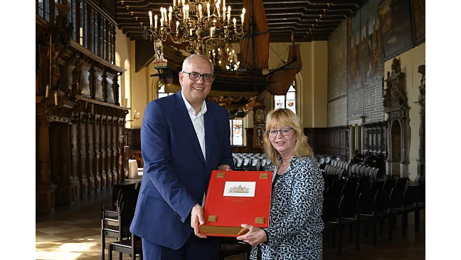 Rathaus-Mitarbeiterin Michaela Lohaus übergibt das neue Goldene Buch an Bürgermeister Andreas Bovenschulte.