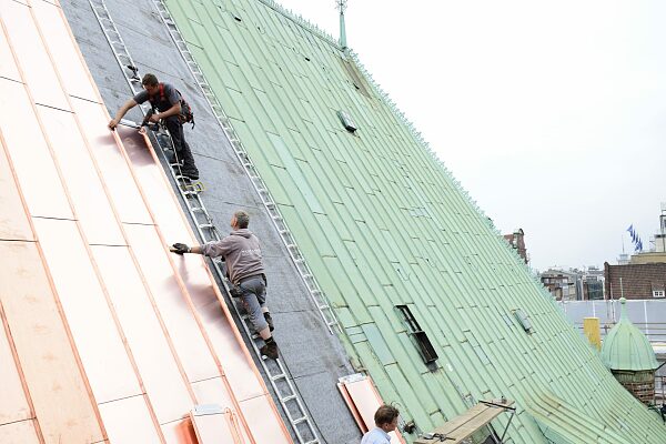 Arbeiter tauschen altes gegen neues Kupferdach des Bremer Rathauses aus.