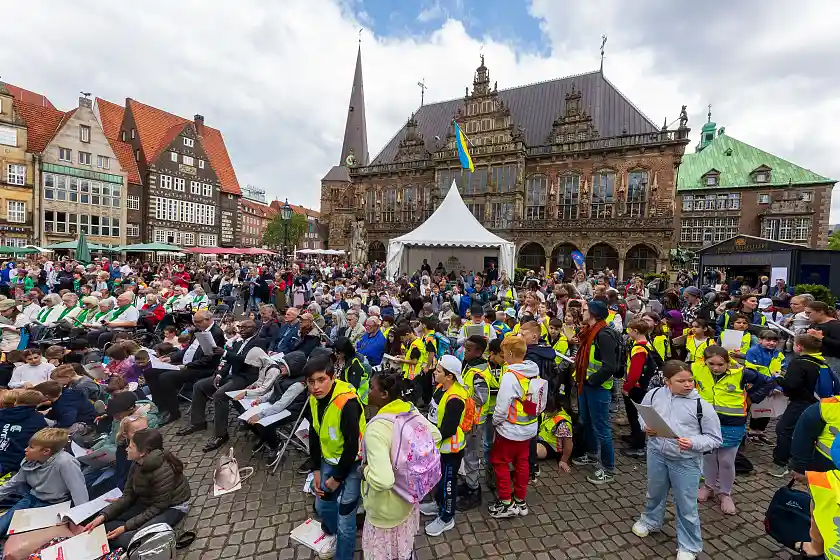 In den Notenheften die Texte für das Mitsingfest – Blick auf dem Marktplatz. 