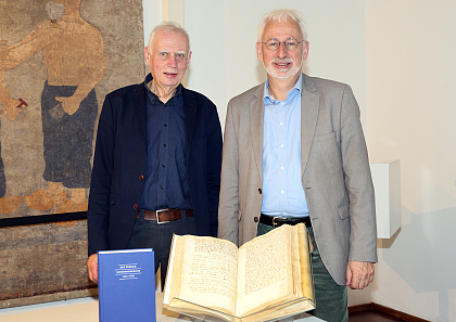 Dr. Ulrich Weidinger (links) und der Leiter des Staatsarchives Bremen, Prof. Dr. Konrad Elmshäuser, präsentieren das Ratsdenkelbuch von 1395.