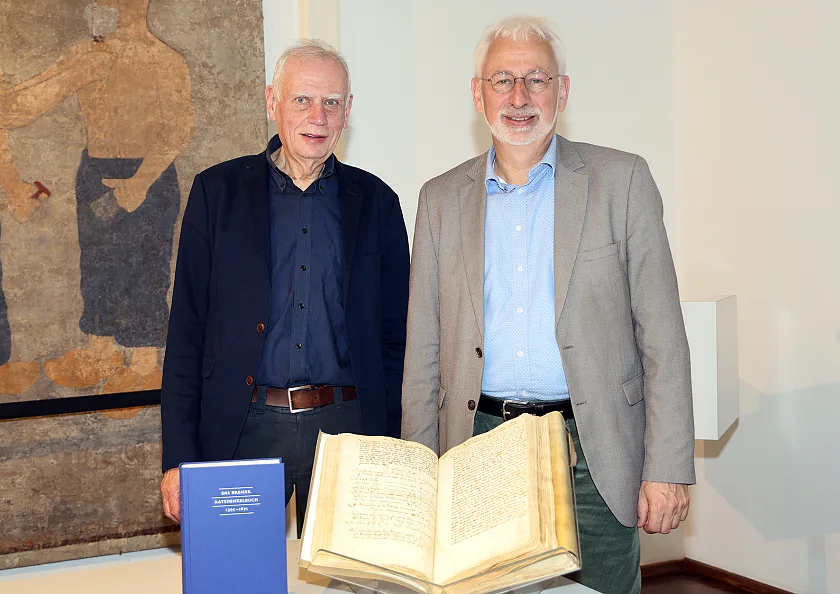 Dr. Ulrich Weidinger (links) und der Leiter des Staatsarchives Bremen, Prof. Dr. Konrad Elmshäuser, präsentieren das Ratsdenkelbuch von 1395.