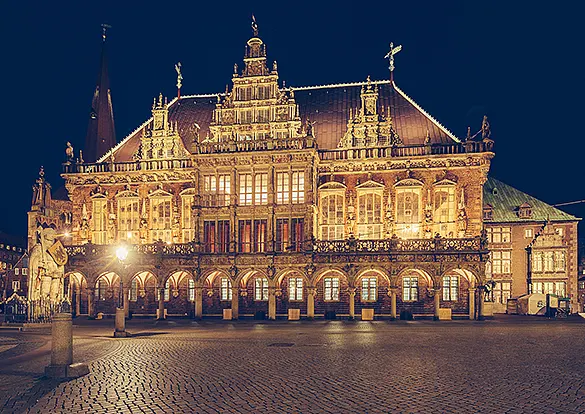 Erleuchtetes Rathaus und der Roland zur blauen Stunde